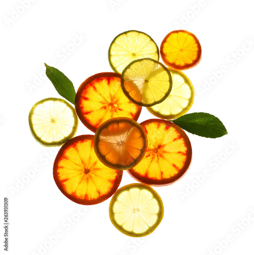 Fototapeta Naklejka Na Ścianę i Meble -  Illuminated slices of citrus fruits and leaves on white background, top view