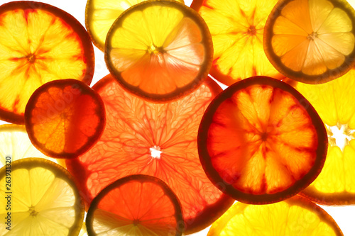 Fototapeta Naklejka Na Ścianę i Meble -  Illuminated slices of citrus fruits on white background, top view