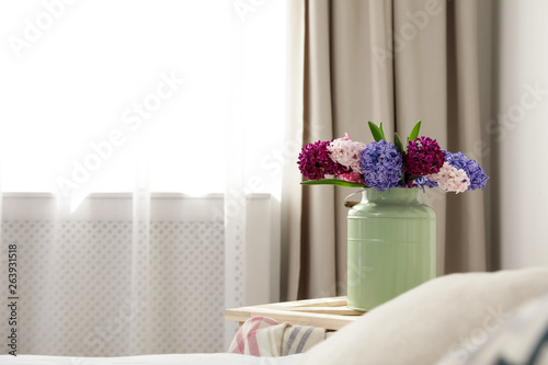 Beautiful hyacinths in metal can on wooden crate indoors  space for text. Spring flowers
