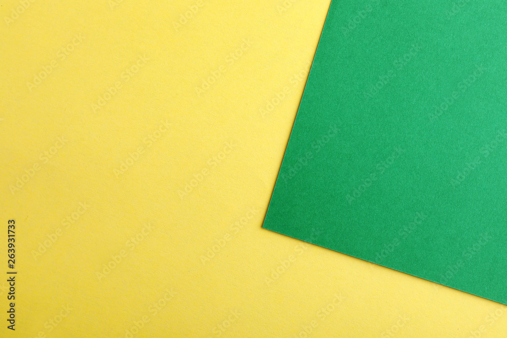 Green and yellow paper sheets as colorful background, top view Green and yellow paper sheets as colorful background, top view