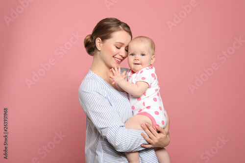 Portrait of happy mother with her baby on color background photo