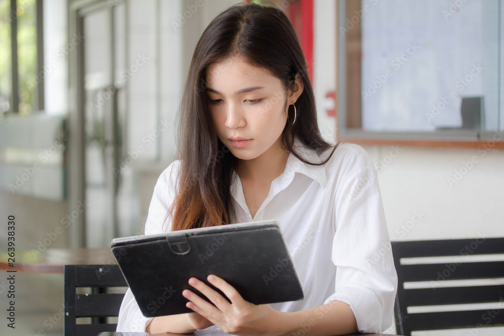 Portrait of thai adult student university uniform beautiful girl using her tablet. Portrait of thai adult student university uniform beautiful girl using her tablet.