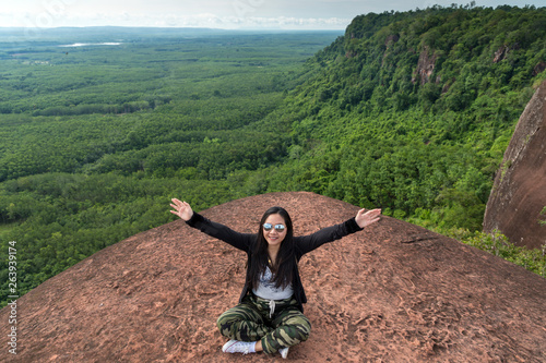 Young woman sitting on a mountain top photo