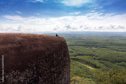 Young woman sitting on a mountain top photo