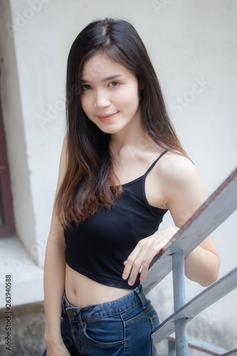 Portrait of thai china adult beautiful girl black shirt blue jeans relax and smile