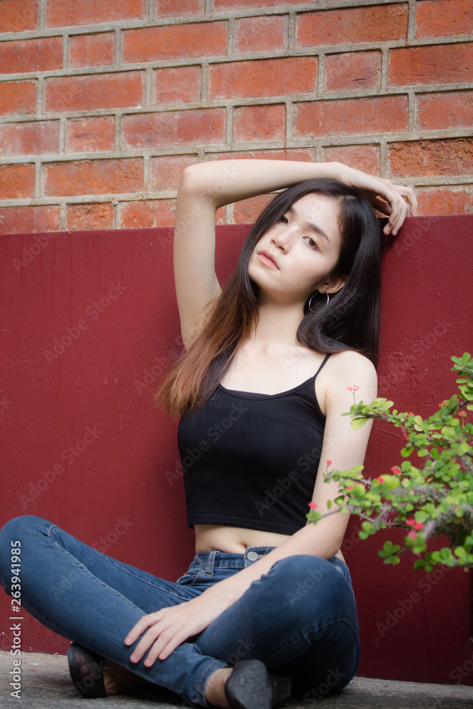 Fototapeta premium Portrait of thai china adult beautiful girl black shirt blue jeans relax and smile
