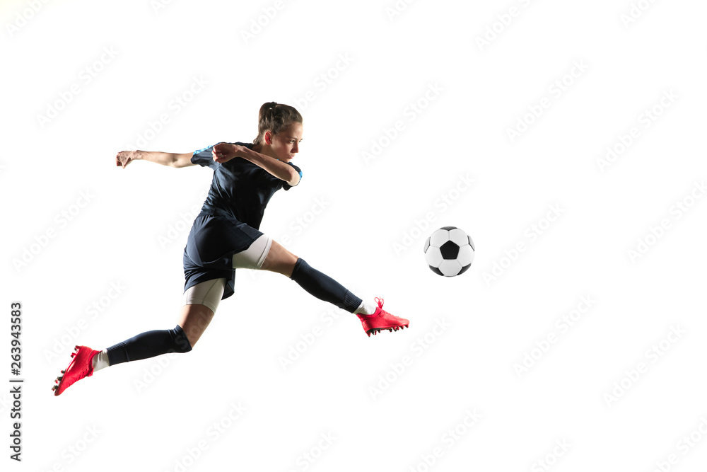 Female soccer player kicking ball isolated over white background