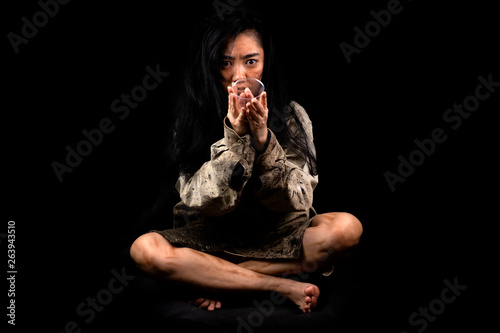 Young and dirty beggar asking for some money, Portrait of young beautiful homeless concept on black background