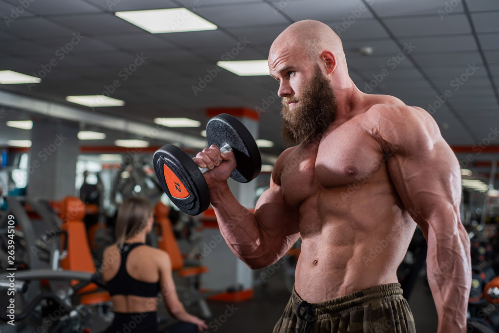 Foto de Brutal, muscular, bald with a beard athlete in the gym