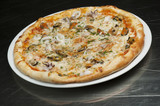 Delicious pizza with cheese, mushrooms and seafood on a black background