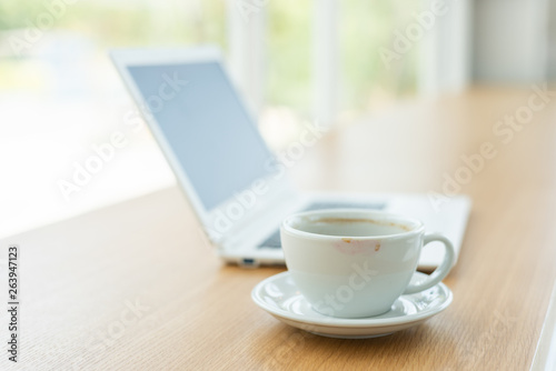 empty cup of coffee with laptop on the table