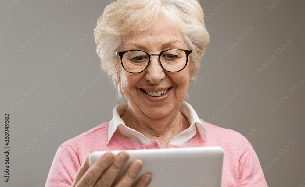 Happy senior lady using a digital tablet Happy senior lady using a digital tablet