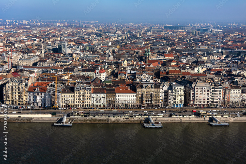 Hungary, Budapest: Skyline from above with Danube Donau river pier, mass of buildings, apartments, rooftops in the city center of the Hungarian capital - concept urban development. Hungary, Budapest: Skyline from above with Danube Donau river pier, mass of buildings, apartments, rooftops in the city center of the Hungarian capital - concept urban development.