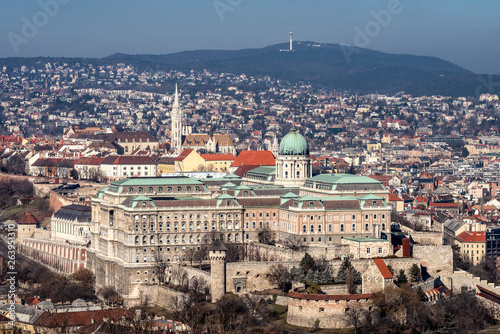 Hungary, Budapest: Famous Buda Castle (Burgpalast) and Matthias Church (Matyas Templom) in the city center of the Hunagian capital from above with skyline, tele tower and blue sky in the background.