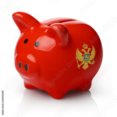 Piggy bank painted in the flag of Montenegro, isolated on white background