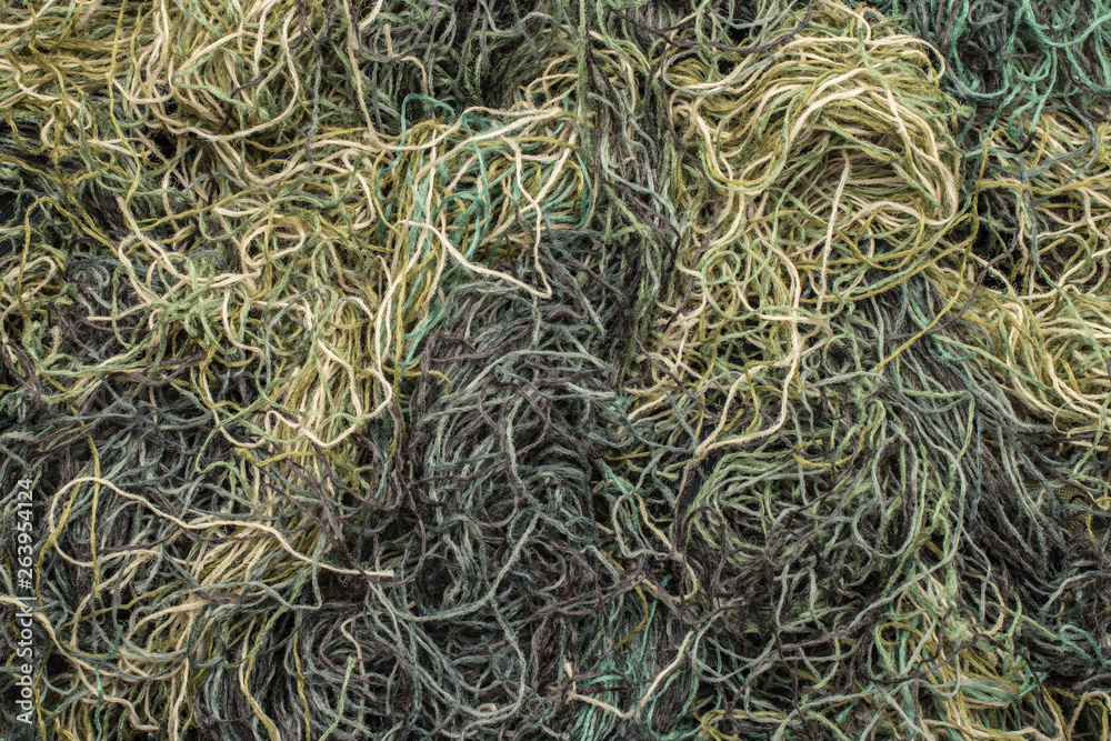 background of colored threads chaotically intertwined. green yellow and brown threads matted in a colorful background background of colored threads chaotically intertwined. green yellow and brown threads matted in a colorful background