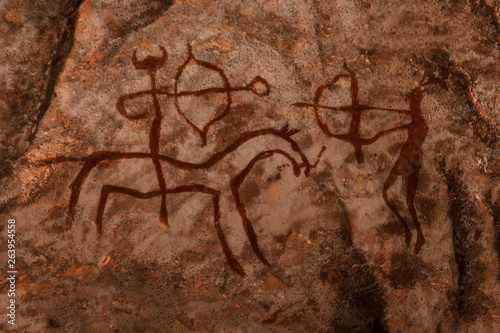 iDrawing of ancient hunters on the wall of the cave. history of antiquities, archaeology.