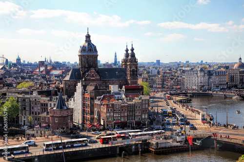 Amsterdam cityscape with Grand Amarath hotel. City streets with active tram and car traffic along the canal. Panoramic distance view. 