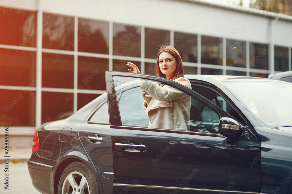 young and elegant business woman standing near car with coffee young and elegant business woman standing near car with coffee