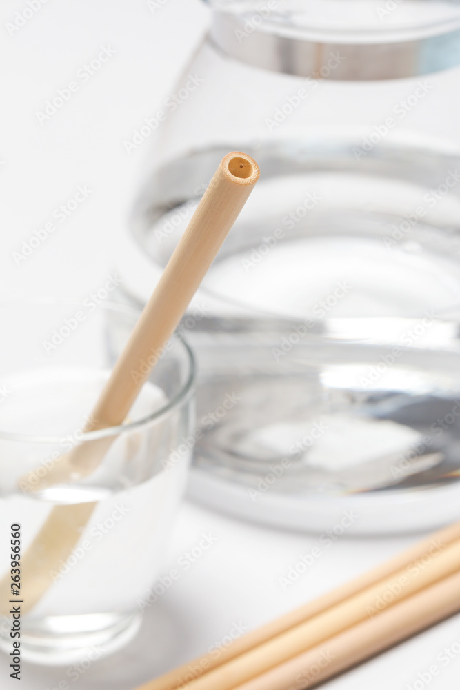 Bamboo straw in a glass of water on the grey background, Reusable bamboo straws as an alternative for single-use plastic straws, healthy and sustainable lifestyle concept Bamboo straw in a glass of water on the grey background, Reusable bamboo straws as an alternative for single-use plastic straws, healthy and sustainable lifestyle concept