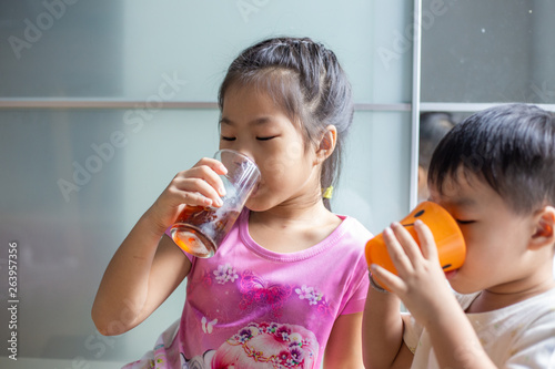 Funny child boy and girl drinking sweet ice drink