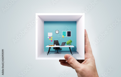 A Man Holding A Miniature Business Office Work Space photo