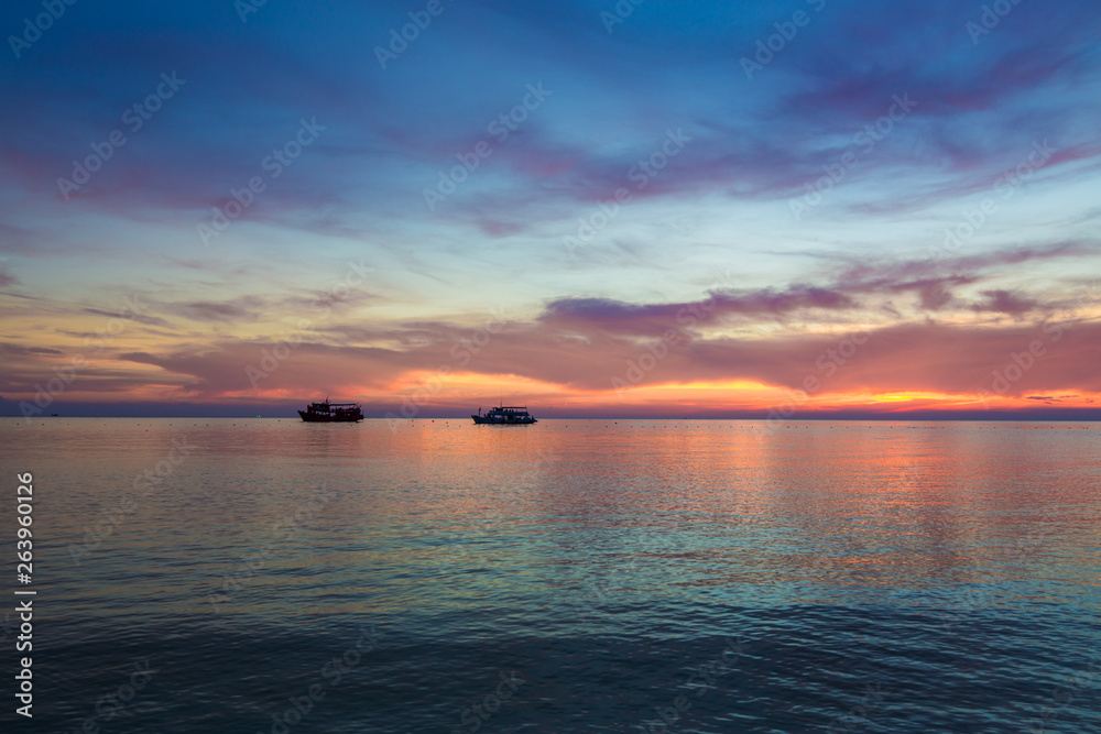 Naklejka premium Silhouette sunset at beautiful beach with colorful sky cloud