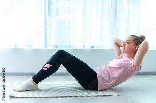Woman doing fitness exercises and workout at home on yoga mat. Lose weight and keep fit. Healthy, sports lifestyle