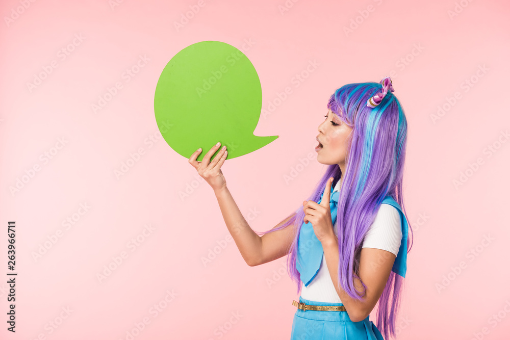 Asian anime girl holding green speech bubble and showing idea sign on pink Asian anime girl holding green speech bubble and showing idea sign on pink