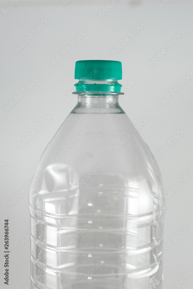Bottleneck of a empty  bottle of a liter and a half of mineral water with  sea green cap and sealing ring on a white background, and space for inserts.  Reuse, Eco-Friendly, Environment