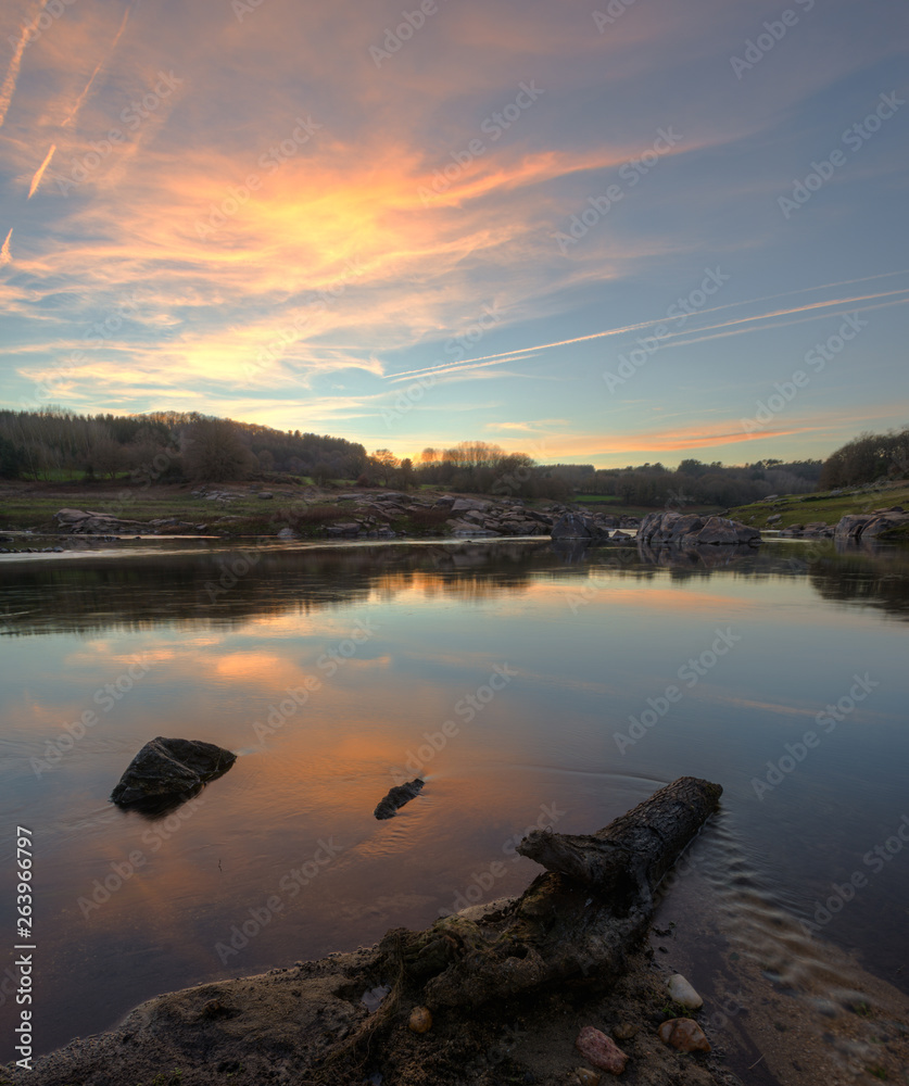 Fototapeta premium Sunset with golden clouds reflected in the river