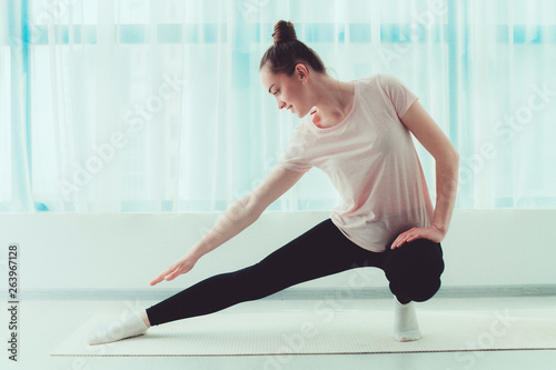 Healthy happy woman do stretching muscle and fitness exercises on yoga mat at home. Lose weight and keep fit. Sports lifestyle