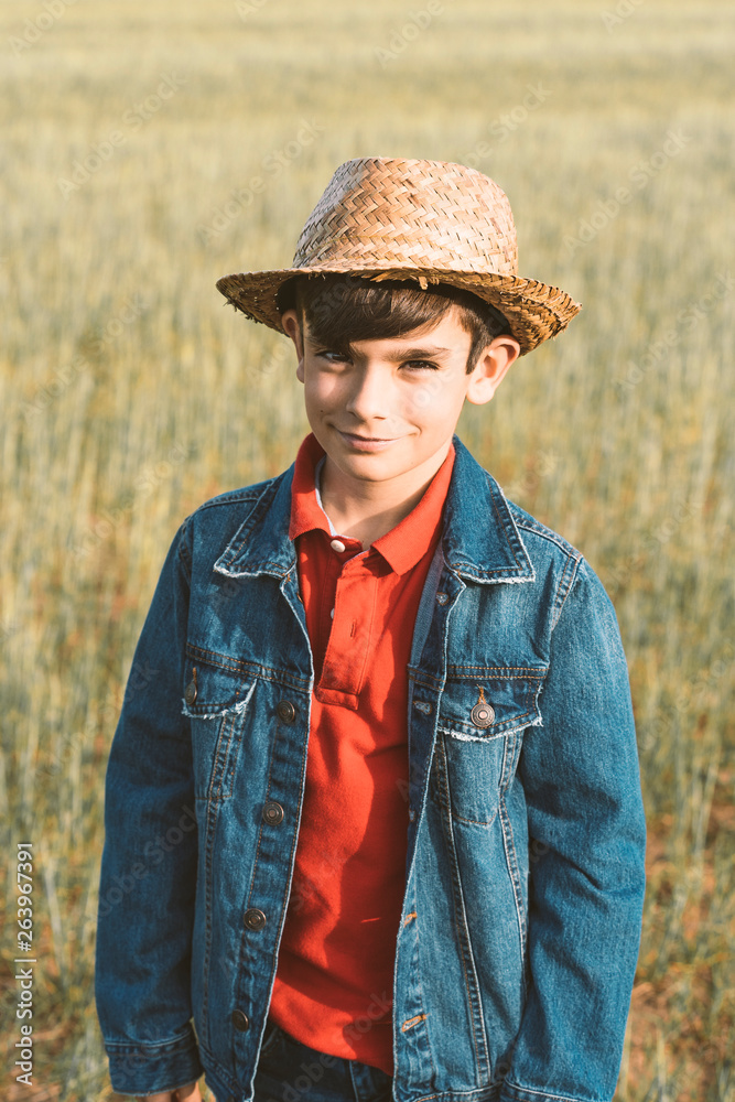 Young boy with hat posing in countryside