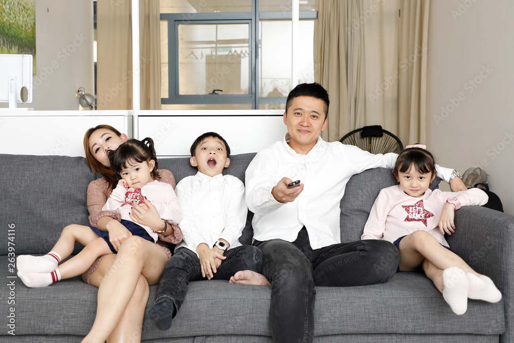 Parents Child Family father mother daughter son sit on sofa watching television entertainment Parents Child Family father mother daughter son sit on sofa watching television entertainment