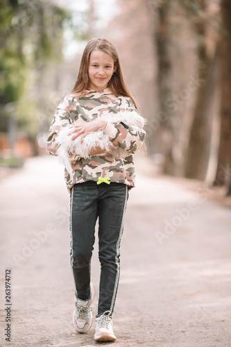 Little girl with a white puppy. A puppy in the hands of a girl © travnikovstudio