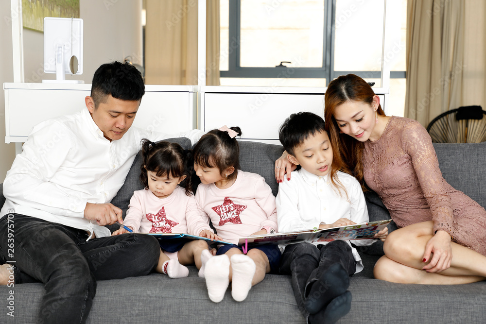 Parents Child Family father mother daughter son sit on sofa reading writing study teaching Parents Child Family father mother daughter son sit on sofa reading writing study teaching