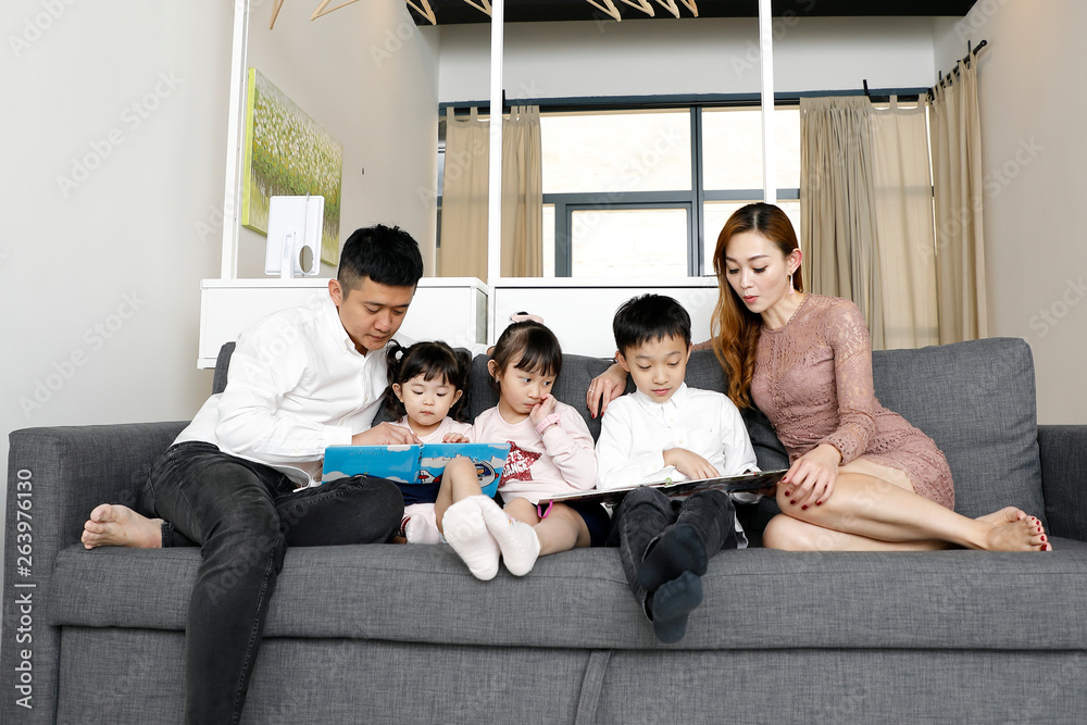 Parents Child Family father mother daughter son sit on sofa reading writing study teaching Parents Child Family father mother daughter son sit on sofa reading writing study teaching