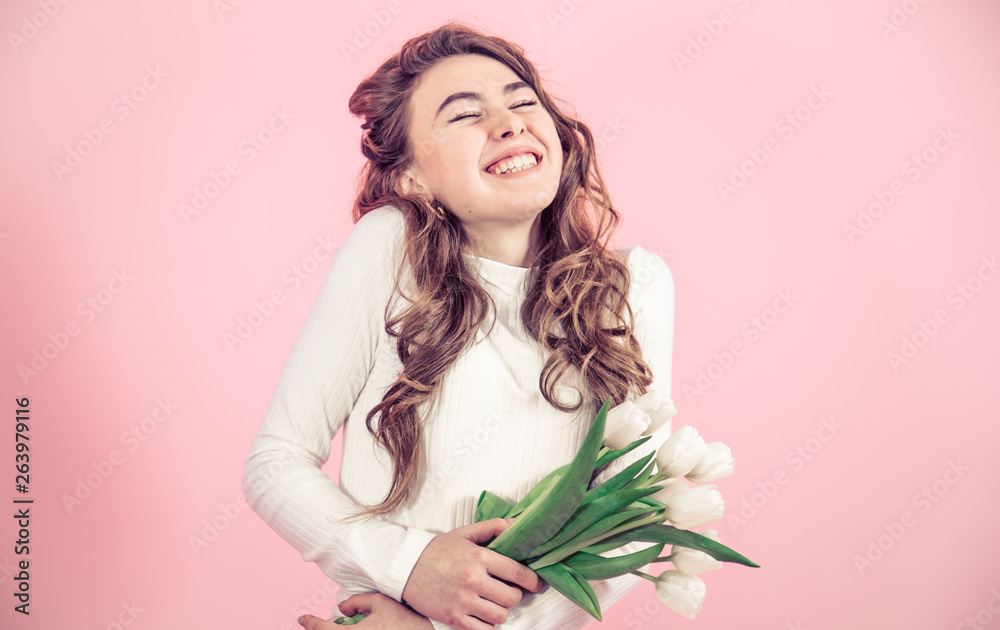 Young girl with tulips on a colored background Young girl with tulips on a colored background