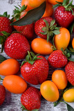 Close-up of strawberries and kumquats. Mix of fruit and berries. Summer background