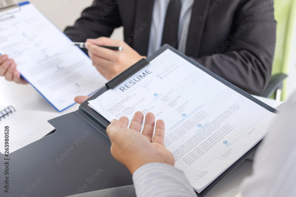 Employer or recruiter holding reading a resume during about colloquy his profile of candidate, employer in suit is conducting a job interview, manager resource employment and recruitment concept