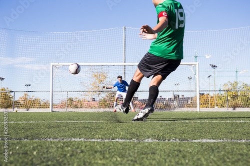 Football player shooting the ball on football field photo