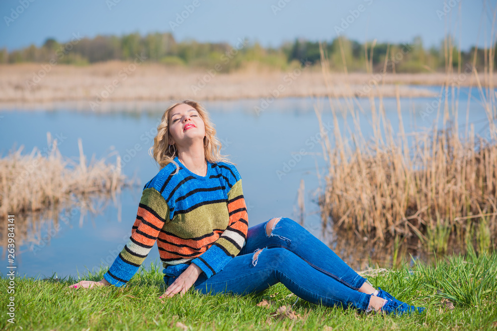 Nice woman in knitted sweater and jeans at forest. Concept of plus size woman, modern beauty and fashion Nice woman in knitted sweater and jeans at forest. Concept of plus size woman, modern beauty and fashion