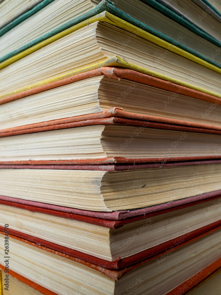Heap of books of different flowers. The old books put on a table. The turned yellow pages of textbooks Heap of books of different flowers. The old books put on a table. The turned yellow pages of textbooks