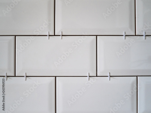 Masonry on the wall of white ceramic tiles. Bathroom or kitchen renovation