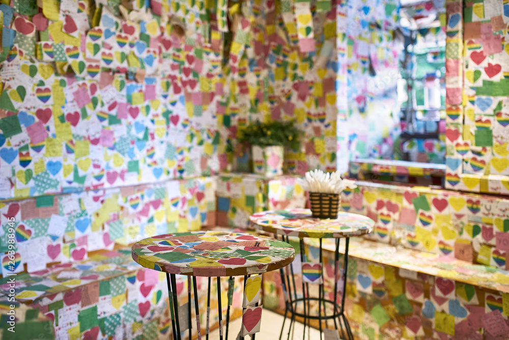 Multicolored postcards pasted on interior of unusual cafe