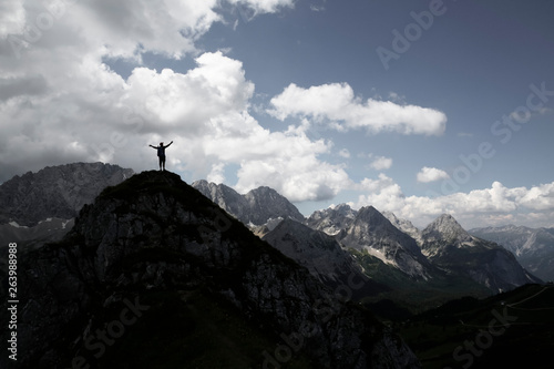 Austria, Tyrol, silhouette of man cheering on mountain peak