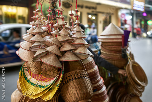 Street seller with asian conical wooden hats and baskets
