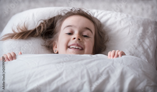 Little cute girl smiling in bed , sleep concept