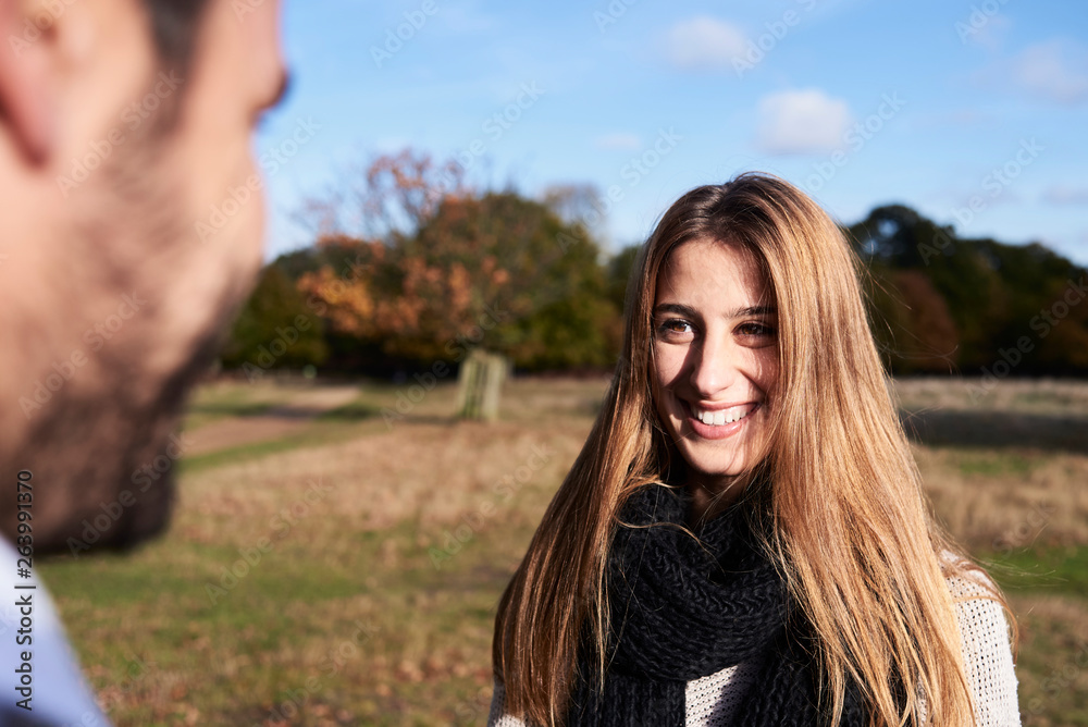 Happy couple in a park smiling at each other Happy couple in a park smiling at each other