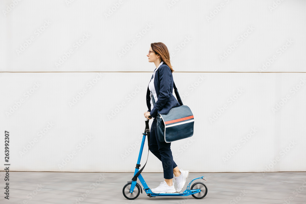 Active businesswoman riding scooter in the city Active businesswoman riding scooter in the city